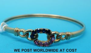 A 9ct gold bangle set with blue and pink sapphires (7.