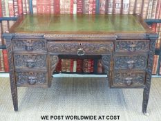 A carved oak desk with mask handles (width 121cm, depth 70cm,