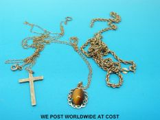A 9ct gold tiger's eye pendant and chain, a crucifix and chain and a 9ct gold necklace (7.