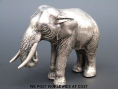 A white metal model of an elephant,