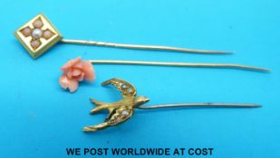 Three yellow metal stick pins one set with coral and seed pearl,