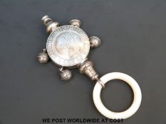 A hallmarked silver baby's rattle with whistle and mother of pearl teething ring