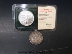 A cased 2001 1oz silver Liberty dollar and an 1878 dollar