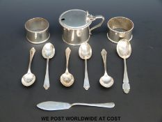 Two hallmarked silver napkin rings, five hallmarked silver tea spoons, a hallmarked silver mustard,