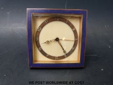 An Art Deco travel alarm clock with blue enamel Greek key border, bevelled glass,