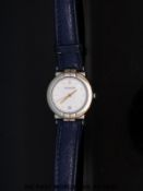 Pequignet ladies wristwatch with gold hands and markers and date aperture on white face,