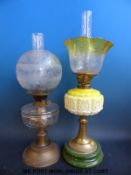 Two glass and brass oil lamps, one with yellow embossed glass,