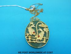 A yellow metal pendant set with a jade plaque on 9ct gold chain