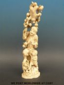 A Japanese Meiji period carved ivory okimono of a man with a performing monkey above his head and a