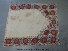 An 18thC Suzani embroidered panel or throw with hand finished decoration of foliage on a cream