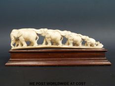 A carved ivory elephant train on stand (length 24cm)