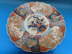 A large 19thC Japanese Imari charger with scalloped edge,