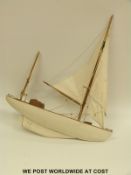 A wooden model yacht on stand, 60 cm long.