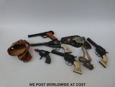 Six replica Colt and other toy pistols,