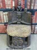 A Chokwe chief's chair carved with typical Chokwe faces and figures with hide and stud decoration