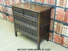 An oak carved chest of two over two drawers with Gothic style carved fronts (W93 x H92 x D46cm)
