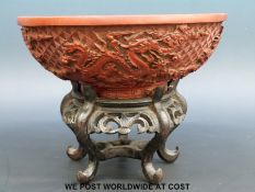 A Chinese carved cinnabar lacquer bowl on wooden stand (diameter 19.