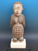 An African tribal maternity figure of a pregnant woman on stone plinth (51cm tall)