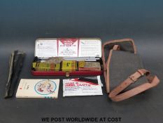 A vintage gun cleaning kit together with a gun slip and book on guns.