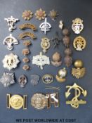 A quantity of military badges and insignia to include naval belt buckle and a gilt anchor,