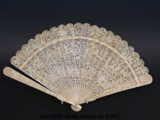 A 19th/20thC carved ivory brise fan, the guard sticks carved with figures and dragons,