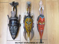 Three African tribal masks with birds to the top and two painted probably Senufo tribe,