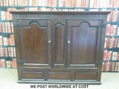 A large oak housekeeping or similar cupboard with arch topped panelled doors (W179 x H146 x D59cm)