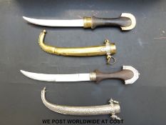 Two Middle Eastern jambiya daggers, one with wooden handle and white metal sheath,