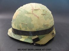 A US Army Vietnam era steel helmet with cover and inner, marked Steinberg Brothers inc.