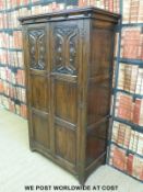 An antique oak style wardrobe with panelled and carved doors (W97 x H168 x D50cm)