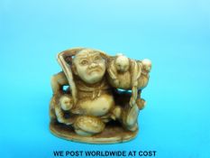 A Japanese Meiji period carved ivory netsuke of a giant with figures in his basket (4.