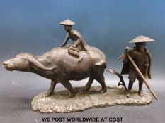 A Thai cast metal figure of a man riding a water buffalo (length approximately 45cm)