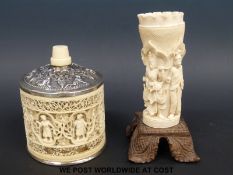 An Indian ivory fretwork pot with white metal lid decorated with figures and a carved ivory vase