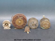 Five vintage fishing reels including three brass examples