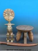 A carved African stool with masked legs together with a fertility figure inset with cowrie shells