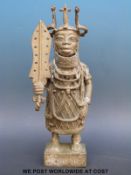 A large Benin bronze figure of a chieftain holding money (34cm tall)