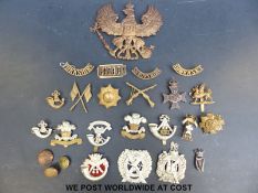 A quantity of military insignia, cap badges etc.