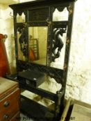 A carved oak hall stand with bevelled mirror to centre (H202 x W107 x D33cm)