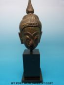 A post Khmer bronze buddha head with gilt remains on mounted base