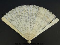 A 19thC Chinese carved ivory fan decorated with figures and dragons