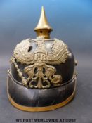 A German late 19thC pickelhaube helmet with embossed insignia and motto 'mit gott fur koenig und