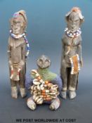 An African tribal figure with all over beaded decoration with two other similar examples (tallest