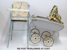 A c1960s small doll's pram with a floral design hood and cover,