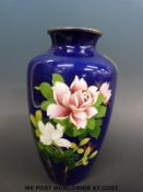 A Japanese cloisonne vase decorated with pink and white roses amongst foliage on a deep blue ground