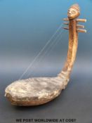 An African tribal figural musical string instrument (length 49cm)