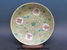 A 19thC Chinese plate with yellow ground, four Chinese symbols and floral decoration,