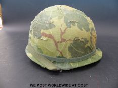 A US Army Vietnam era steel helmet with cover and inner,