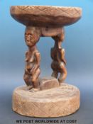 An African figural tribal stool with female and male figures supporting the seat on their heads