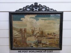 A framed embroidery of a castle with moat,