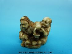A Japanese Meiji period signed carved ivory netsuke of a horned figure pouring liquid into a